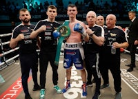 a group of boxers posing with their belts