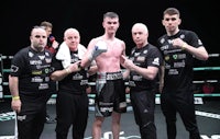 a group of boxers posing for a picture in a boxing ring