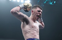 a boxer with his hands raised in the air