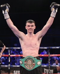 a boxer with his hands raised in the air