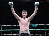 a boxer with his hands raised in the air